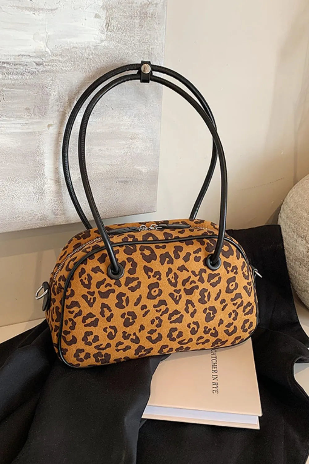 Medium leopard print suede shoulder bag with black handles, stylish and lightweight for everyday use.