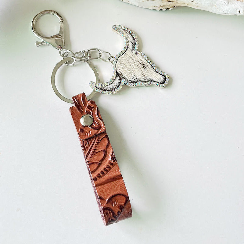 Rhinestone bull head keychain with genuine leather strap and silver alloy ring, measuring 5.8 inches long.