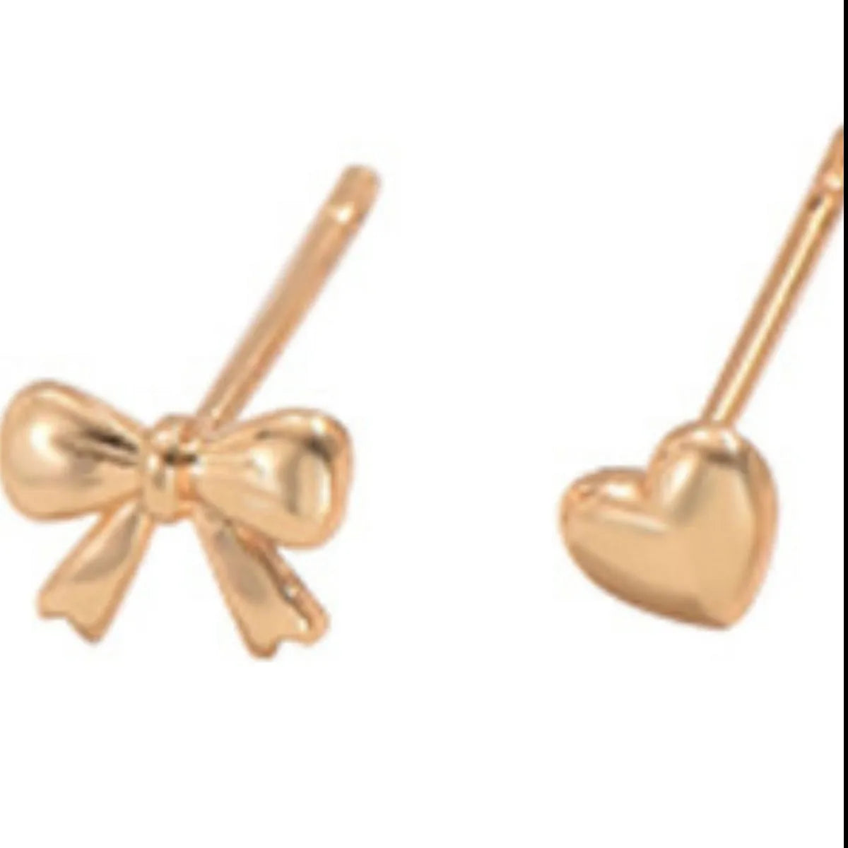 Close-up of 18K gold-plated bow and heart stud earrings with a shiny, polished finish from a 6-piece set.