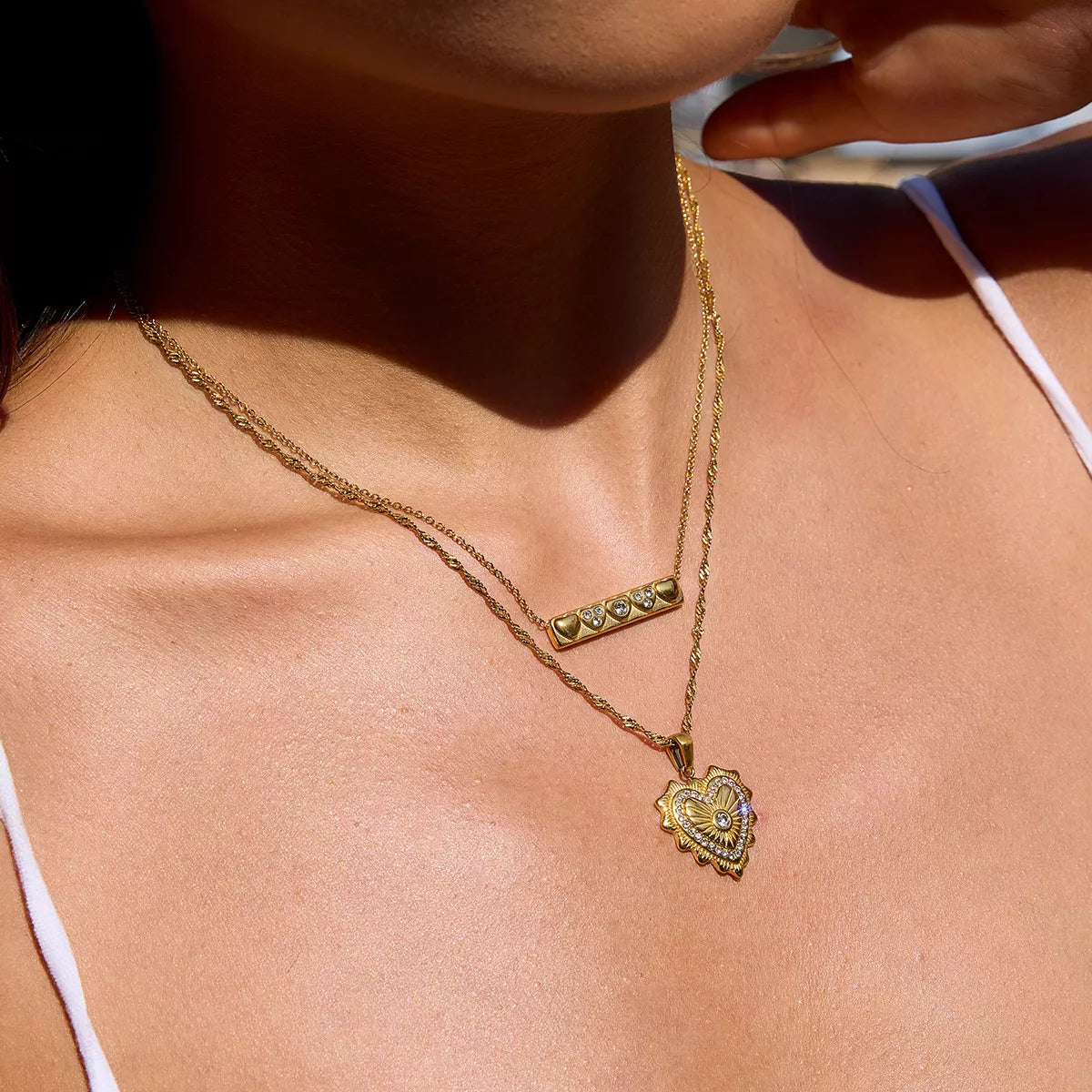 18K gold-plated heart pendant necklace with zircon accents on a delicate gold chain worn on a woman's neck