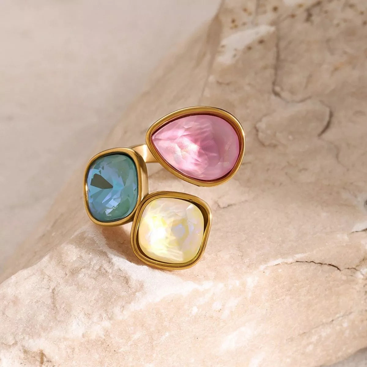 Adjustable 18k gold plated ring with pink, blue, and yellow gemstone rhinestones set in an elegant bypass design
