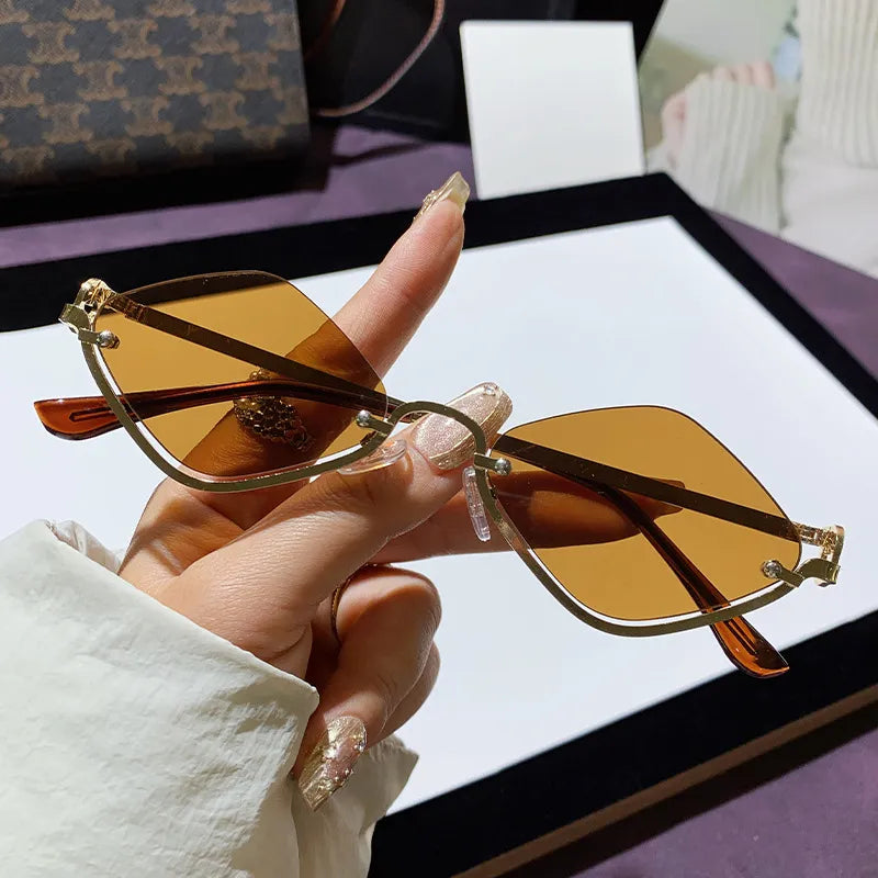 Hand holding cat eye sunglasses with brown lenses and metal-plastic hybrid frame on a purple surface
