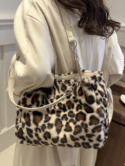 Soft faux fur leopard print shoulder bag with adjustable strap worn over beige coat by a woman