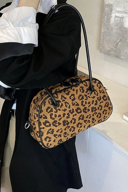 Medium-sized leopard print suede shoulder bag with black handles, stylish and lightweight for everyday use.