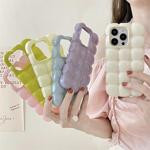 Person holding a textured iphone case with other similar cases in the background.