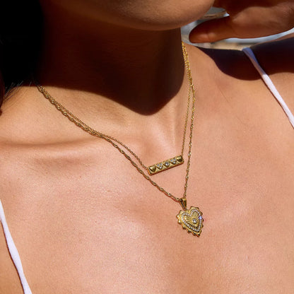 18K gold-plated heart pendant necklace with zircon accents on a delicate gold chain worn on a woman's neck