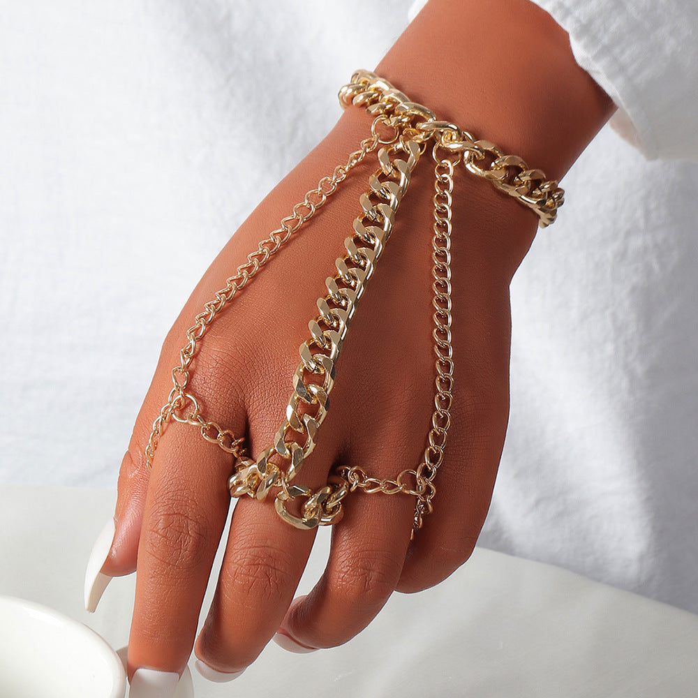 Hand wearing multiple gold chain bracelets on a white background