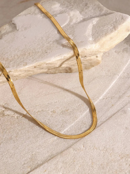 18K gold-plated three-layered cross necklace chain made of durable stainless steel on stone surface background
