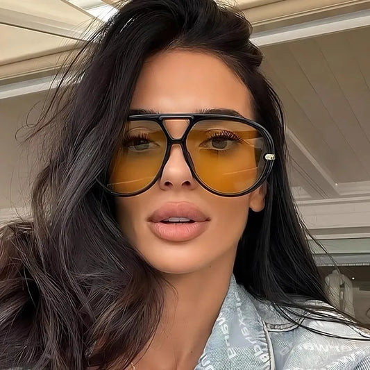 Close-up of woman wearing aviator fashion sunglasses with yellow tinted lenses and black polycarbonate frame
