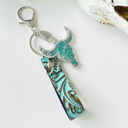 Rhinestone bull head keychain with turquoise tooled leather strap and silver alloy hardware, 5.8 inches long.